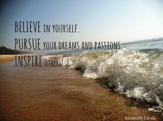 Inspirational quote on sandy beach with ocean waves and blue sky background