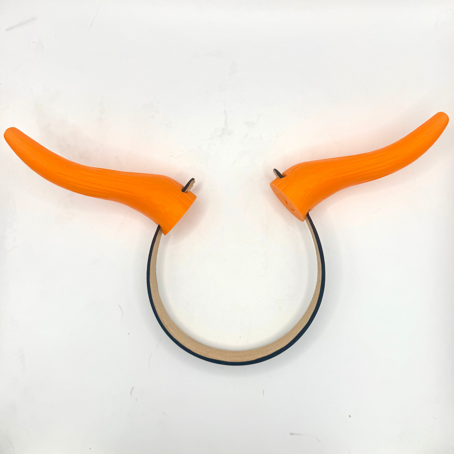 An orange horn-shaped accessory with a curved black band, photographed on a plain white background.